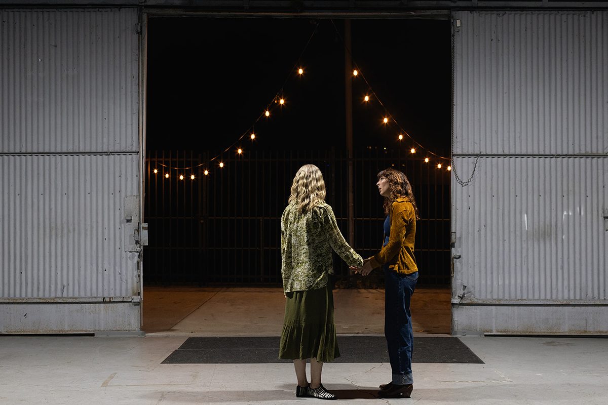 two women standing in front of a door